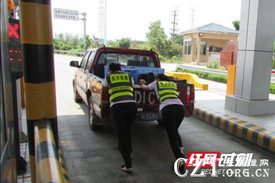 收费人员完成收费流程的同时,组织另外工作人员帮助司机合力推车。