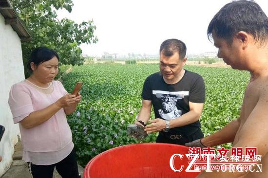 王国顺(中)指导养殖户规范养殖标准。图片来源:湖南文明网