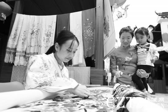 10月1日,铜官窑古镇湖湘非遗文化体验展在铜官窑古镇弘文广场开集,手工艺人正展示湘绣工艺。图/记者金林