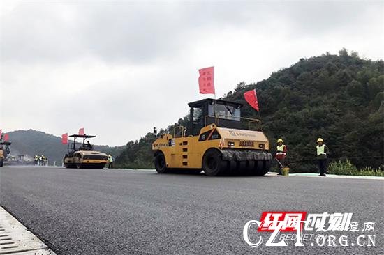在莲株高速公路施工现场,工人们正紧张有序地进行沥青路面摊铺作业。