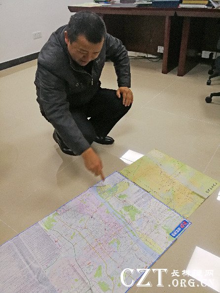 10月23日,蒋连军通过对他收藏的不同时期地图对比,分析改革开放40年长沙城的发展变迁。新华社记者段羡菊摄