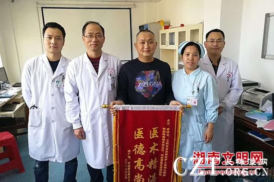 患者送来锦旗感谢胡军(右一)。图片来源:湖南文明网