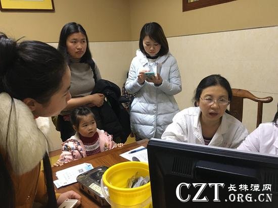 儿科医生正在为患儿看诊,焦急的家长等候挤满了诊室。胡翠娥 摄
