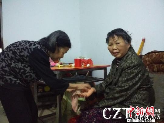 李新彩老人(左)帮张满英洗脸。 谢丽萍 摄